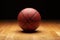 Basketball with spot lighting on hardwood maple basketball court floor