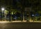 A basketball stand and a lay of light from streetlamp in an outdoor playground in the night