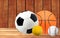 Basketball, tennis, baseball and soccer ball on the wooden table