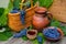 Baskets and bowl with grapes. Jar and cup with wine stand on on rustic wood