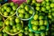 Baskets of fresh rounded organic lime fruit background in bright yellow and green color selling in market under sunlight