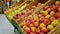 Baskets on supermarket shelves full of yellow and red apples.