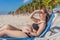 Basking in seaside tranquility, a pregnant woman lounges on a sun lounger, embracing the soothing ambiance of the beach