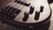 Bass electric guitar with four strings closeup. Detail of popular rock musical instrument. Vintage style photo of control knobs of