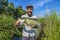 Bass fishing. Happy fisherman with big bass fish. Largemouth perch at pond