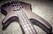 Bass guitar with four strings closeup. Detail of popular rock musical instrument. Close view of brown electric bass on carpet,