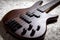 Bass guitar with four strings. Popular rock musical instrument. Close view of brown electric bass on carpet