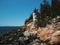 Bass Harbour lighthouse situated atop a rocky shoreline, overlooking the vast expanse of the ocean.