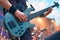 Bassists hands skillfully play electric guitar on vibrant concert stage
