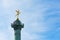 Bastille column with french flags against blue sky in Paris