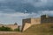 Bastion of the medieval Narva castle Herman. Estonia. In the foreground is the flag of Estonia. In the background is an