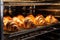 A batch of aromatic and golden croissants baking to perfection in a professional oven, fresh croissants in rack in bakery oven, AI