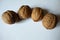 Batch of four ripe brown rounded fruits of Persian walnut