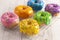 A Batch of Rainbow Donuts on a White Wood Table