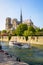 A bateau-mouche cruising on the Seine river in front of Notre-Dame de Paris cathedral