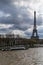 A bateau-mouche on the Seine near the Eiffel Tower on a day with dramatic sky, Paris, France