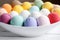 bath bombs in variety of colors in a white bowl