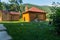 Bath in a house with wooden walls with a brick pipe located in a beautiful place against the backdrop of green mountain