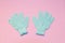 Bath massage blue gloves for shower with exfoliating hydro peeling scrub effect on soft pink background. Top view, flat lay