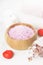 Bath salt with aroma of a rose in a wooden bowl, petals and a fr