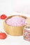 Bath salt with aroma of a rose in a wooden bowl, petals and a fr