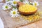Bath salt on wooden spoon with chamomile on mat