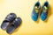 Bath slippers and sports sneakers. Pool slippers and running shoes. Yellow background