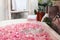 Bath tub with flower petals filling with water
