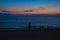 Bathers on a sea beach after sunset