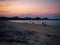 Bathers at sunset on a sandy beach of south Sardinia.