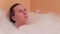 Bathing young woman relaxing in bath
