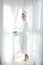 Bathrobe woman sunny window white curtains