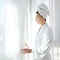 Bathrobe woman sunny window white curtains