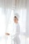 Bathrobe woman sunny window white curtains