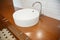 Bathroom ceramic sink with chome water tap and wooden table