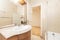 Bathroom with cherry wood cabinet with integrated mirror, cream-colored marble countertop, stoneware floors and shower cabin with