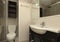 Bathroom with dark wood vanity, semicircular single sink,