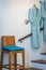 Bathroom detail shot with bath robe bathrobe hanging on the wall and a high decoration chair in front next to stairs