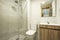 Bathroom with exposed white brick walls with wooden vanity,