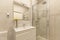 Bathroom with faux marble tiles, walk-in shower with sliding glass doors,