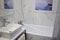 The bathroom has a modern design. In the photo, a sink, a bath, a curtain
