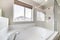 Bathroom interior with bathtub, shower stall and window