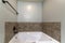 Bathroom interior with drop in tub with brown tile surround