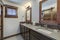 Bathroom interior with grey quarts countertop, two mirrors and barn style doors