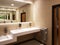 Bathroom interior in light beige and white colors. Round ceramic washbasins. Mirrors, plastic soap dish and chrome faucets for
