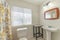 Bathroom interior with table and pedestal sink with framed mirror