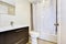 Bathroom interior with vanity cabinet and white shower curtain.