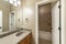 Bathroom interior with white doors and bathtub room with brown tiles corner shelf and surround