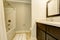 Bathroom interior in white tones with black vanity cabinet.