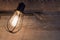 Bathroom lighting with rustic metal light bulb cage on a background of weathered wood